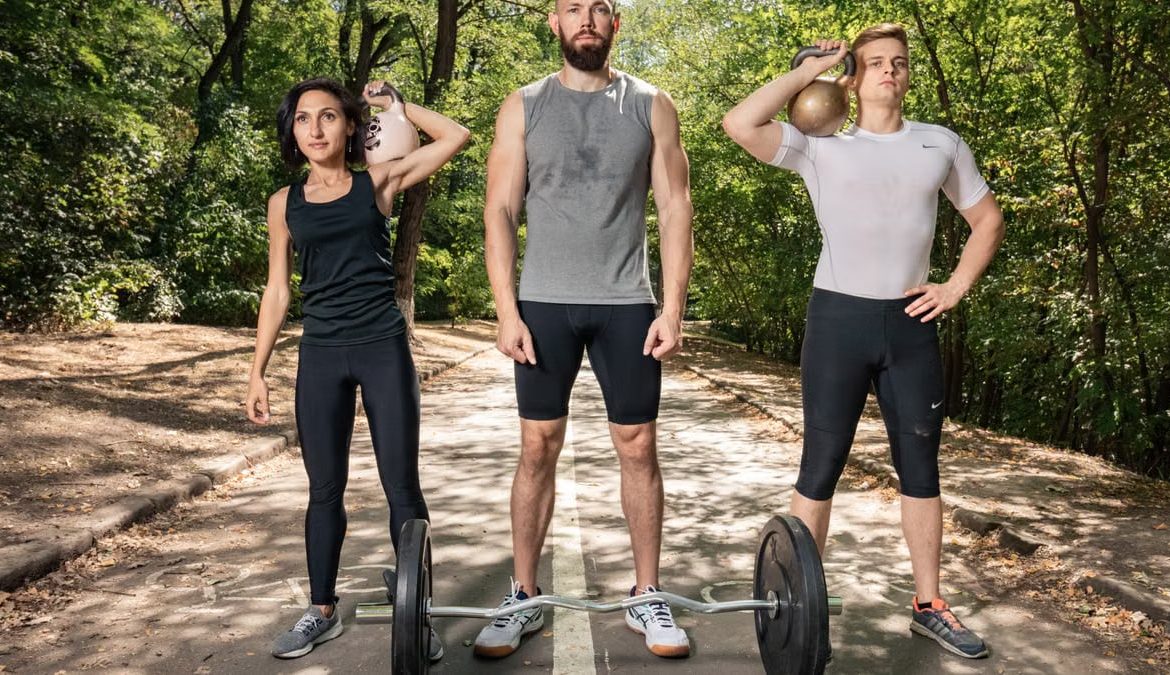 Three adults exercising outdoors with weights, promoting fitness and diversity.
